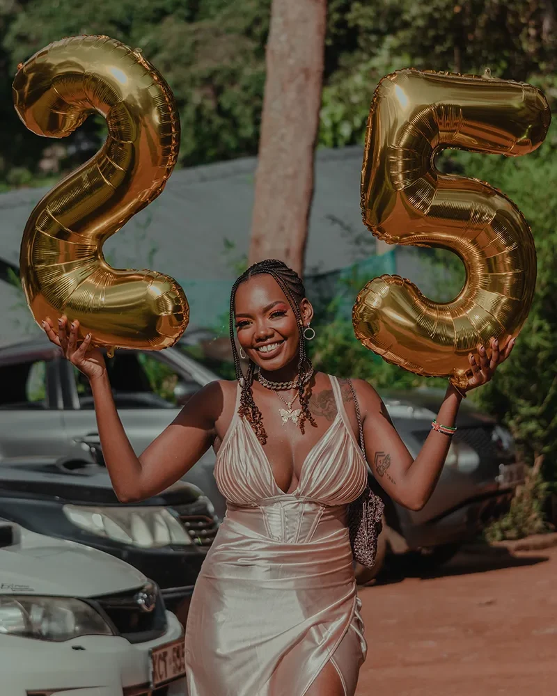 Girl holding up birthday baloons